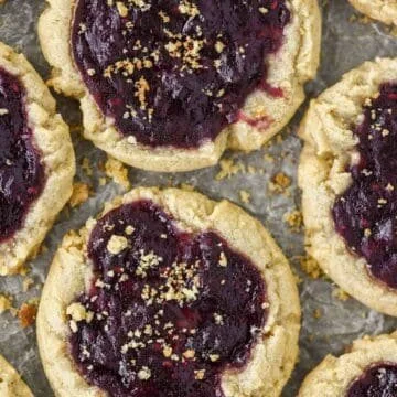 Batch of peanut butter and jelly cookies on a baking tray