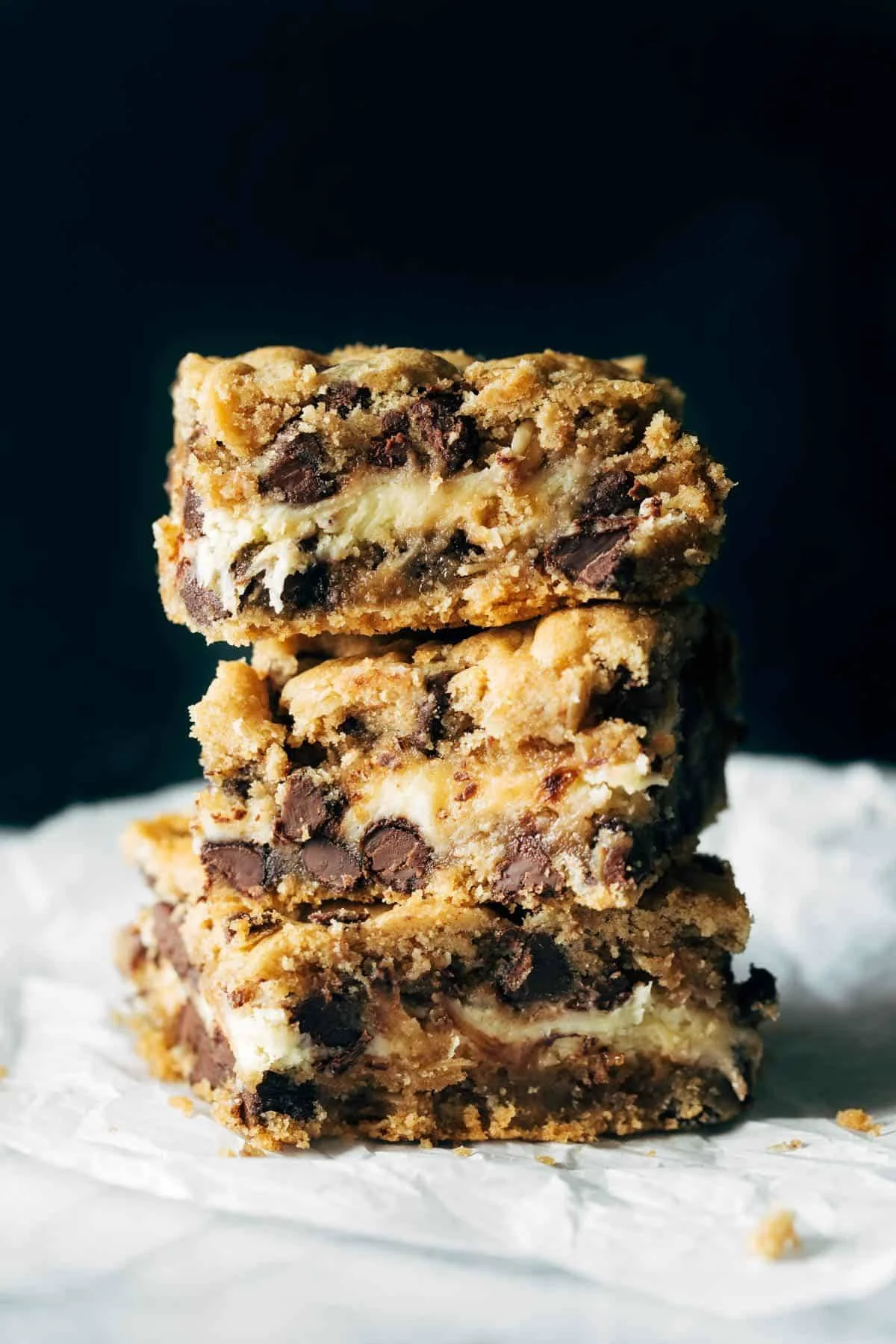 Peanut butter chocolate chip cookie cheesecake bars on a plate