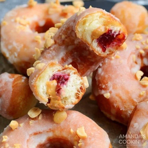 Peanut Butter & Jelly Donuts stacked on a plate with colorful sprinkles