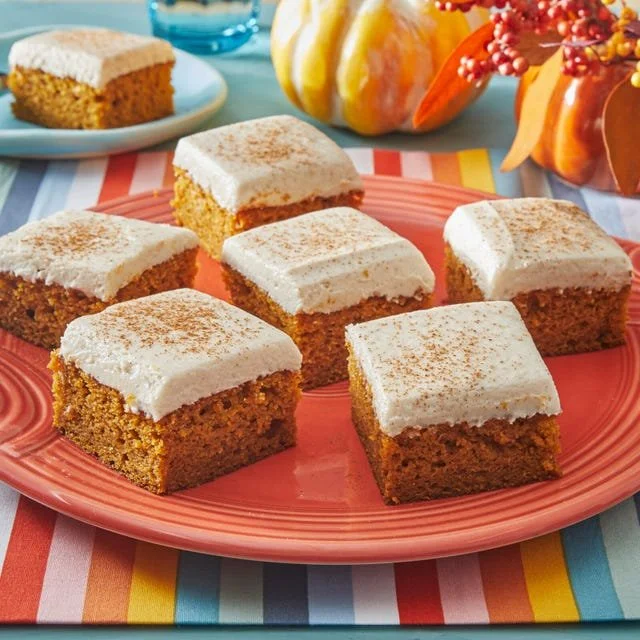 Pumpkin bars with spiced cream cheese frosting on a serving platter