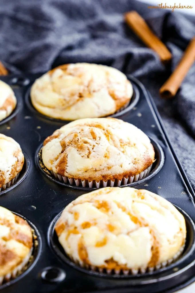 Delicious Pumpkin Cheesecake Swirl Muffins on a wooden table