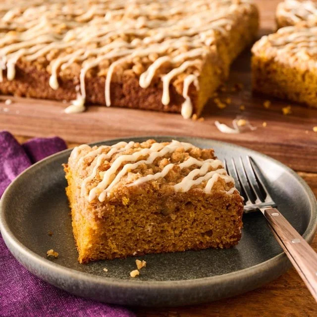 Slice of moist Pumpkin Coffee Cake with a sweet glaze on a plate