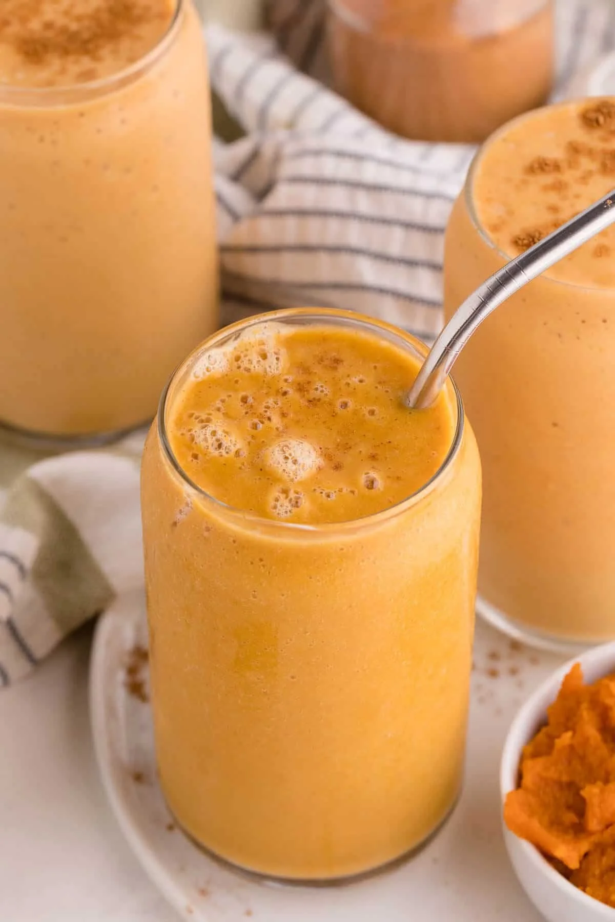Delicious pumpkin pie smoothie topped with whipped cream and spices