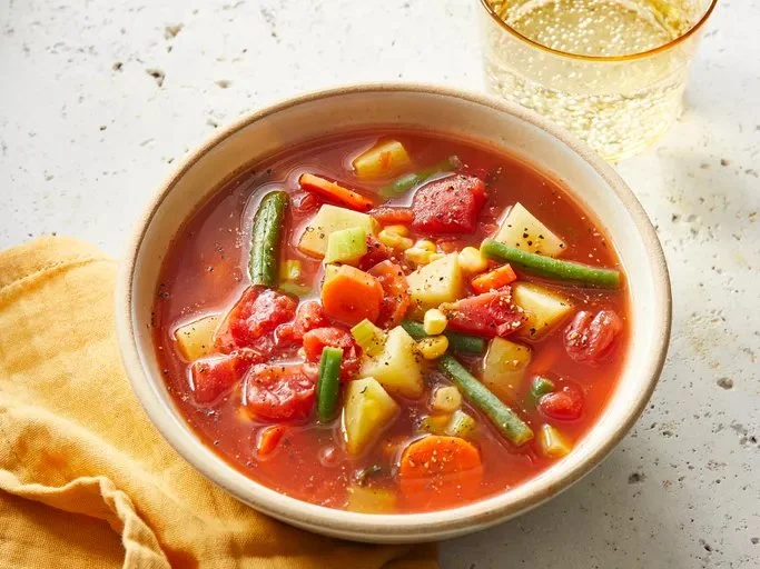 Bowl of quick and easy vegetable soup with fresh vegetables and herbs