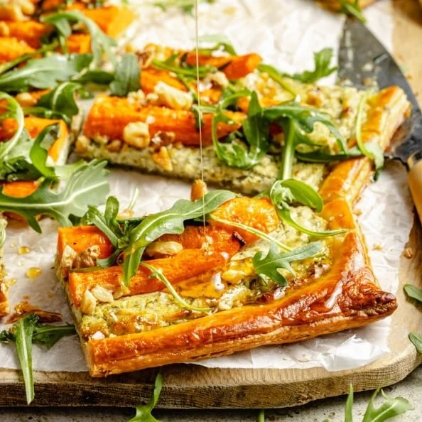 Roasted carrot puff pastry tart topped with herbed goat cheese garnish