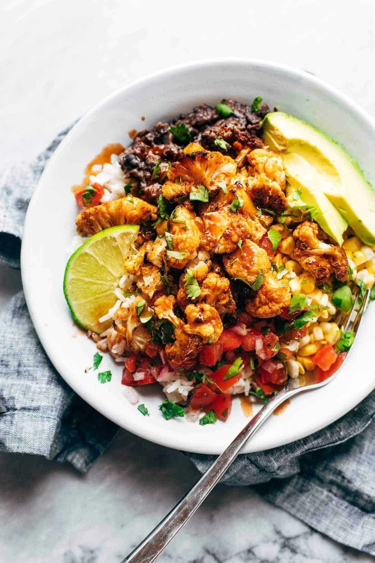 Delicious roasted cauliflower burrito bowls topped with fresh ingredients
