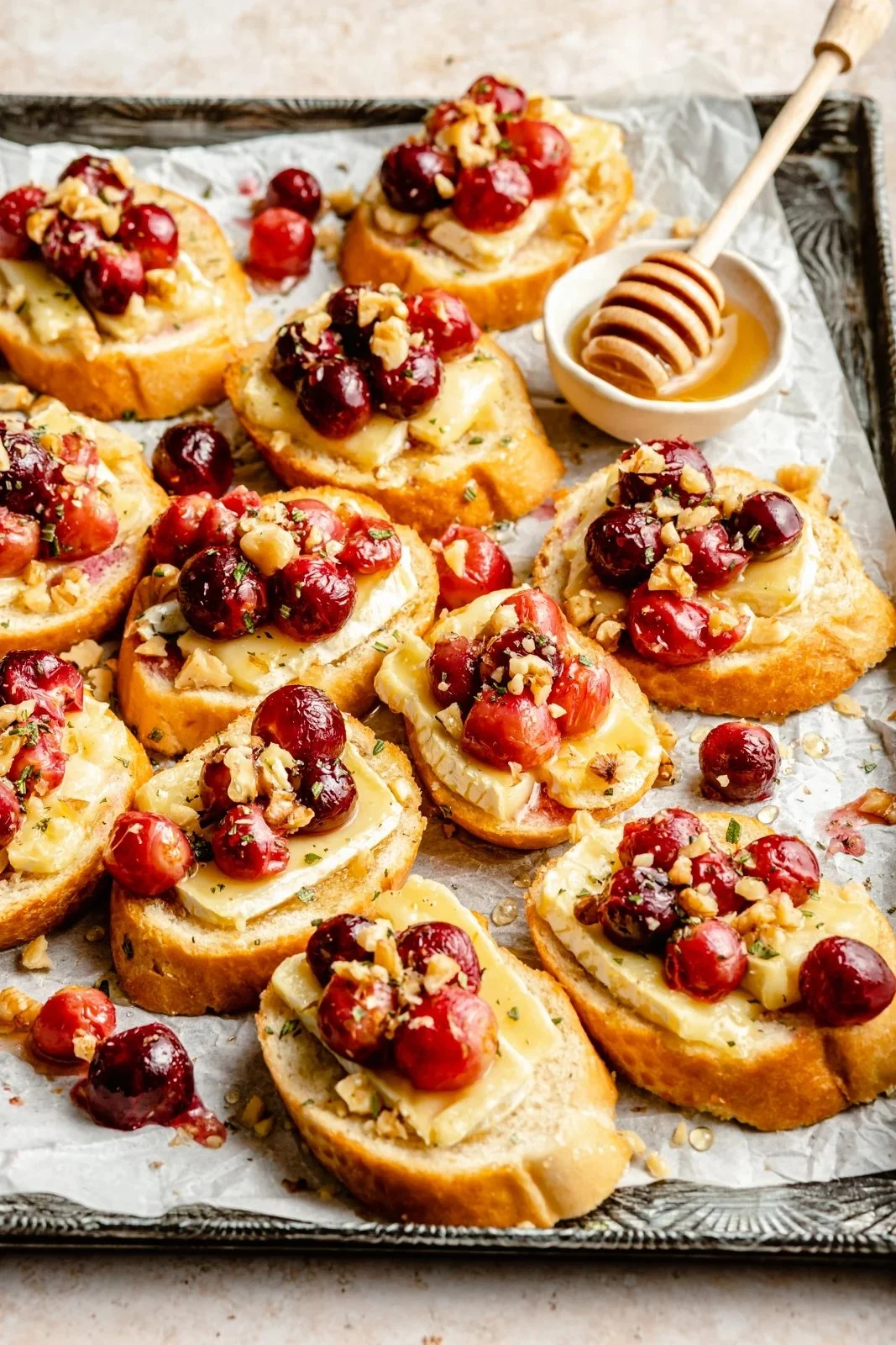 Roasted Grape Crostini with Brie, honey, and sea salt served on a rustic platter