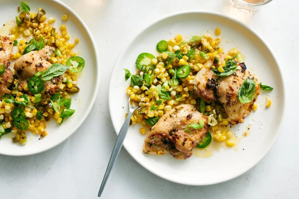 Sheet-pan spicy chicken thighs with corn served on a platter