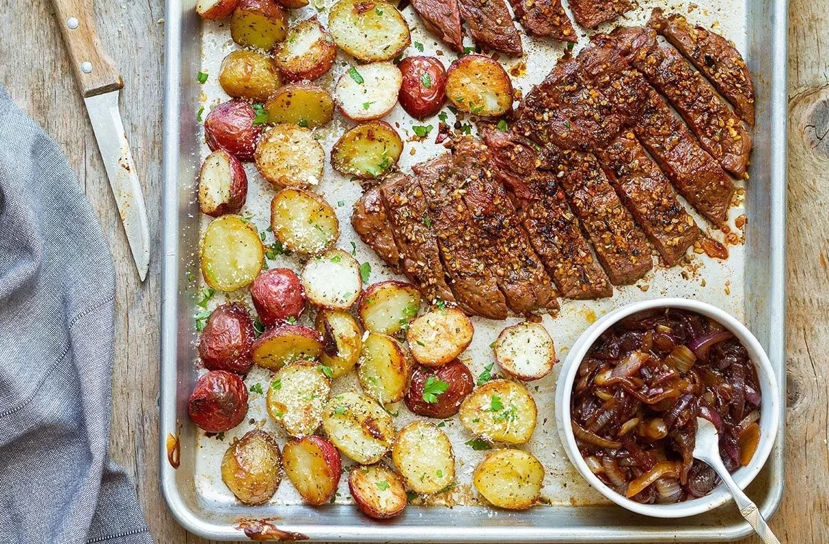 Sheet pan steak and potatoes with caramelized onions ready to serve.