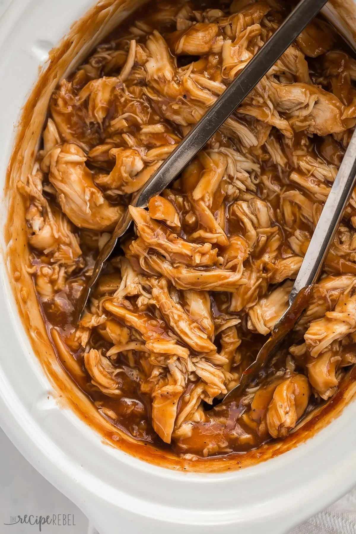 Delicious slow cooker BBQ chicken garnished with herbs and served on a plate