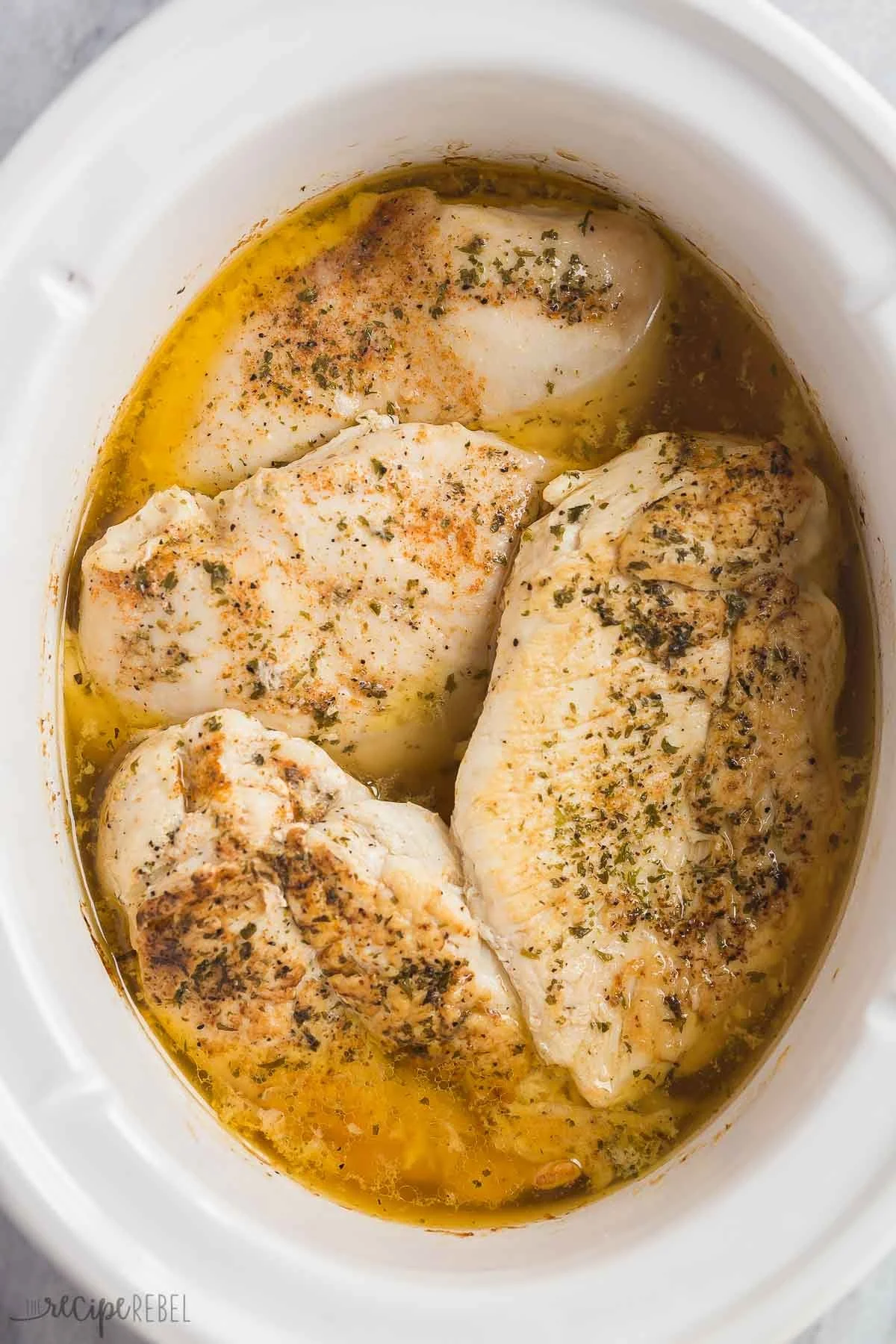 Tender slow cooker chicken breast served with vegetables and herbs