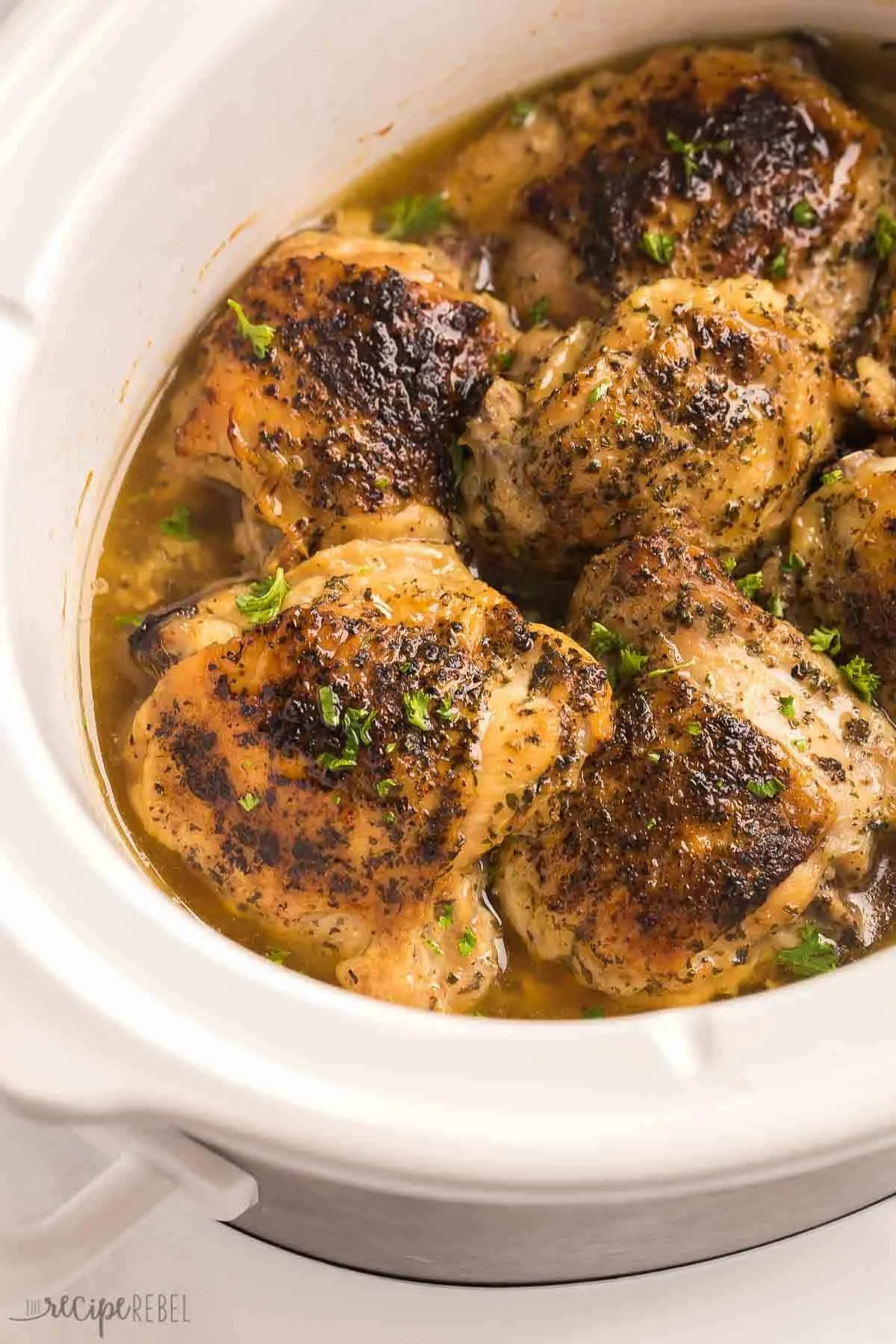 Slow cooked chicken thighs served with herbs and vegetables