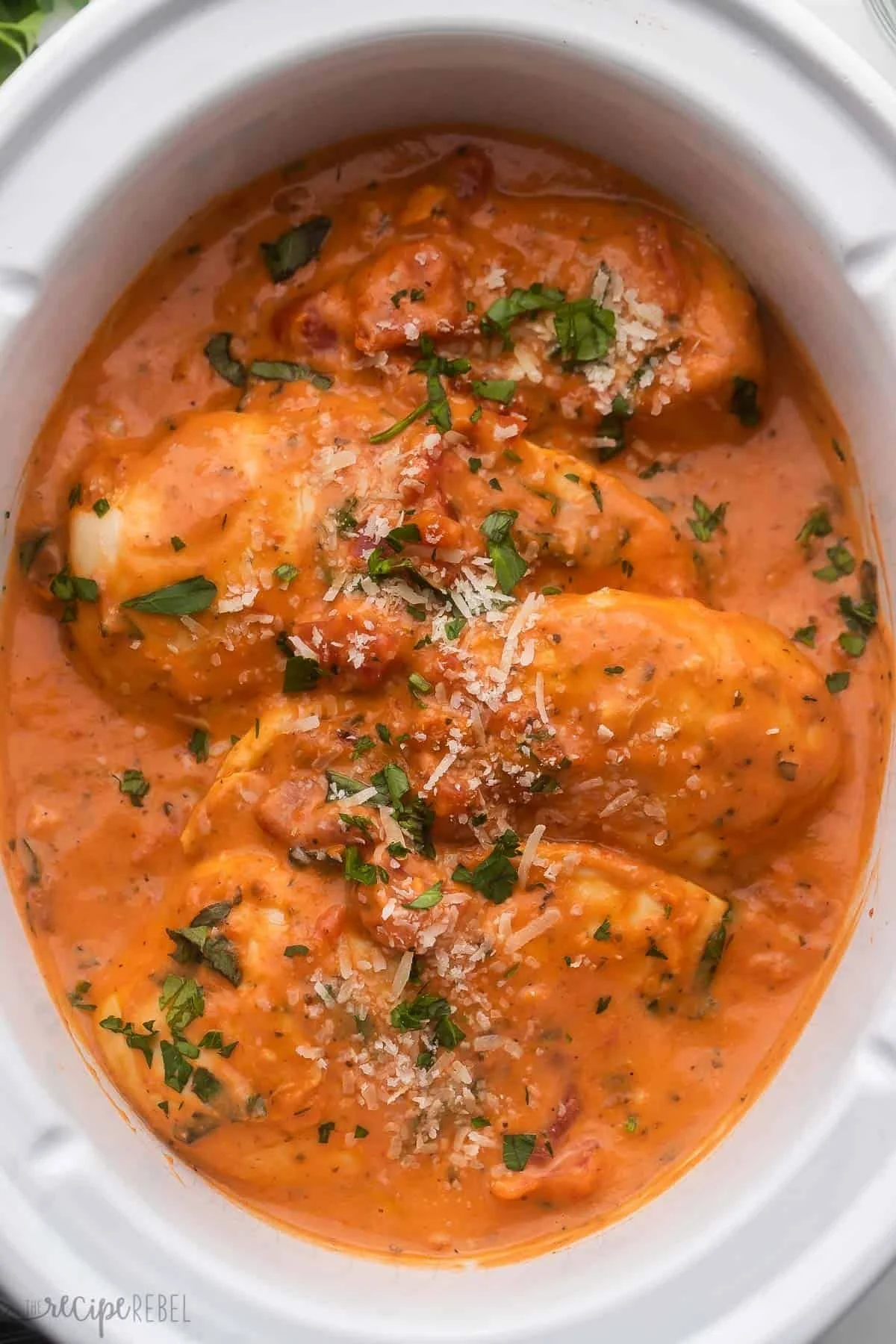 Slow Cooker Creamy Tomato Basil Chicken dish served with fresh herbs