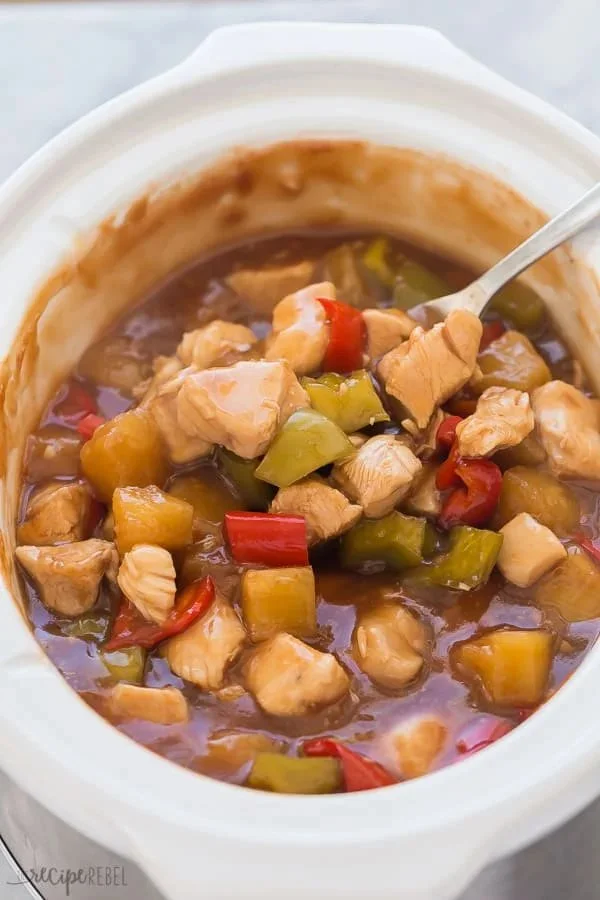 Slow Cooker Sweet and Sour Chicken dish served on a plate with rice and vegetables.