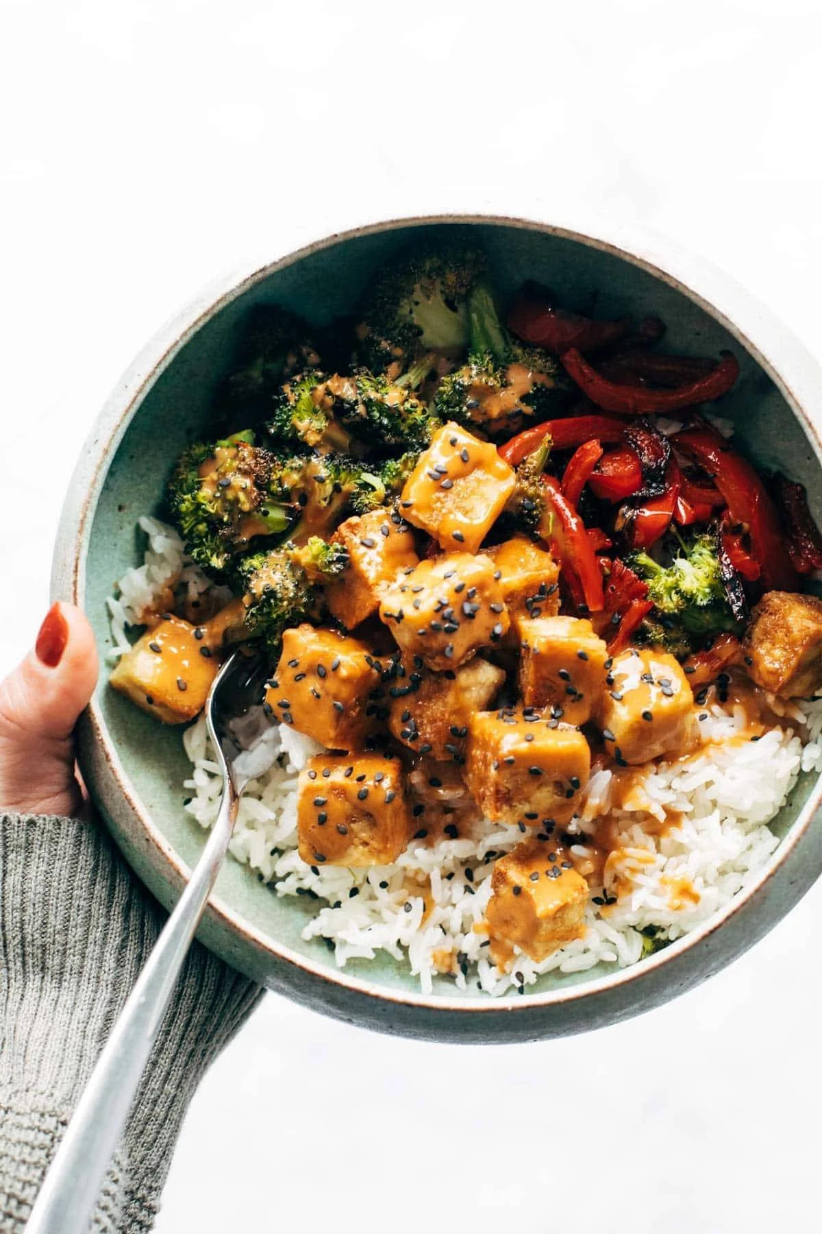 Spicy Peanut Tofu Bowls with vegetables and sauce on a plate
