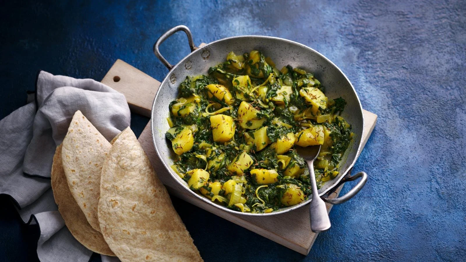 Bowl of cooked spinach potatoes, showcasing a healthy and tasty dish.