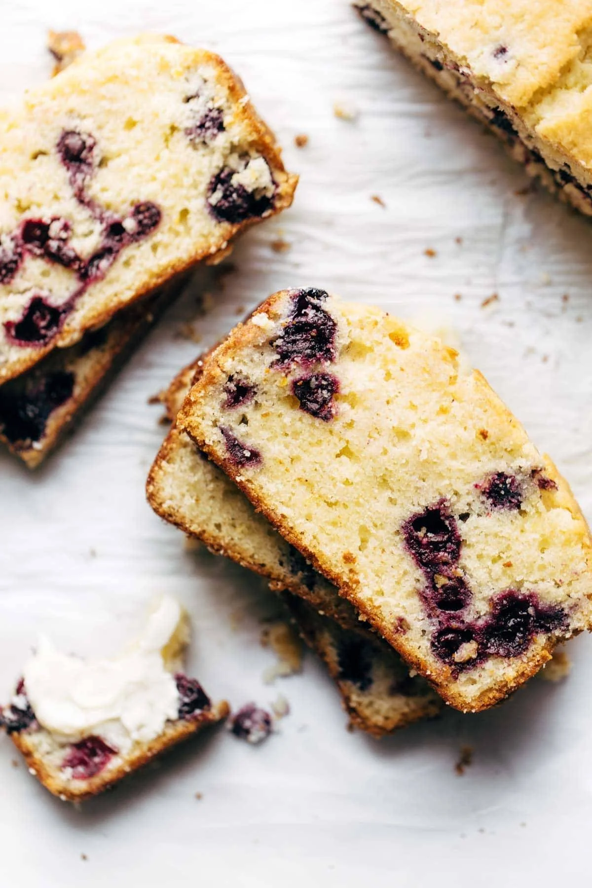 Slice of springy blueberry lemon bread with blueberries on top.