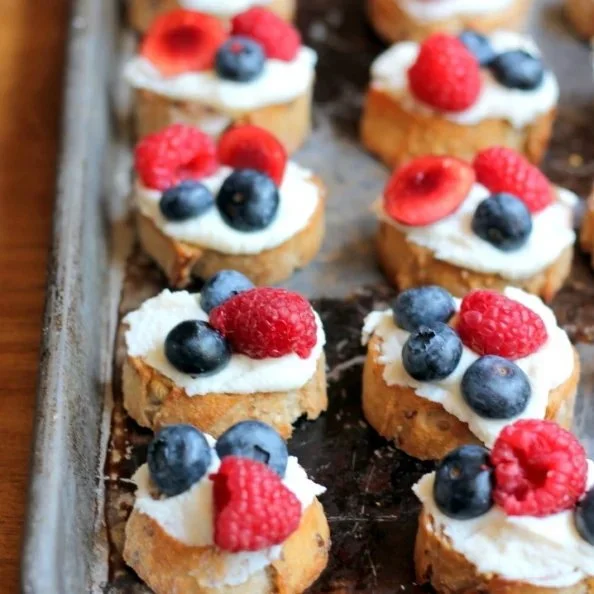 Delicious summer berry crostini topped with lemon ricotta and honey