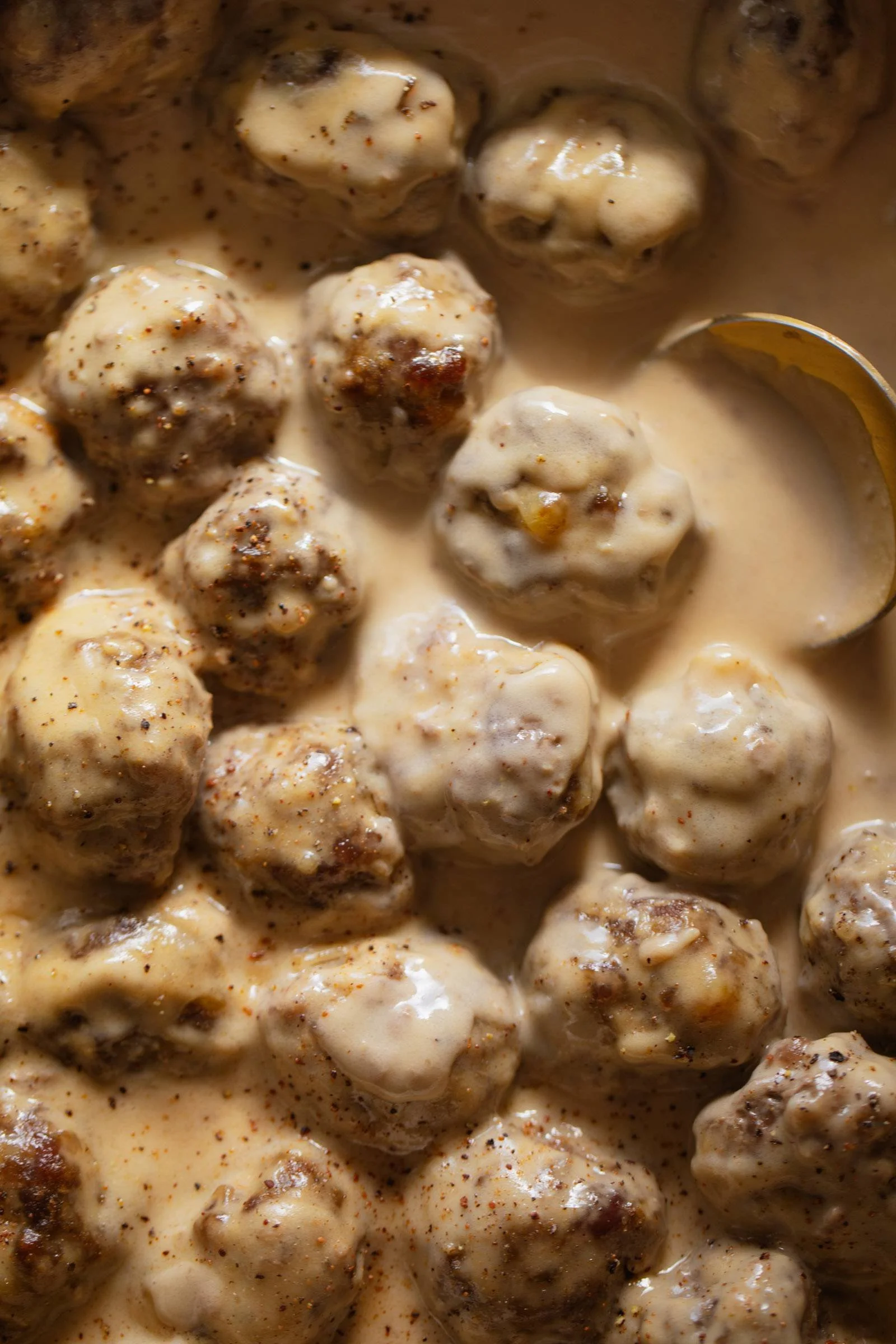 Delicious plate of Swedish meatballs with creamy sauce and fresh herbs