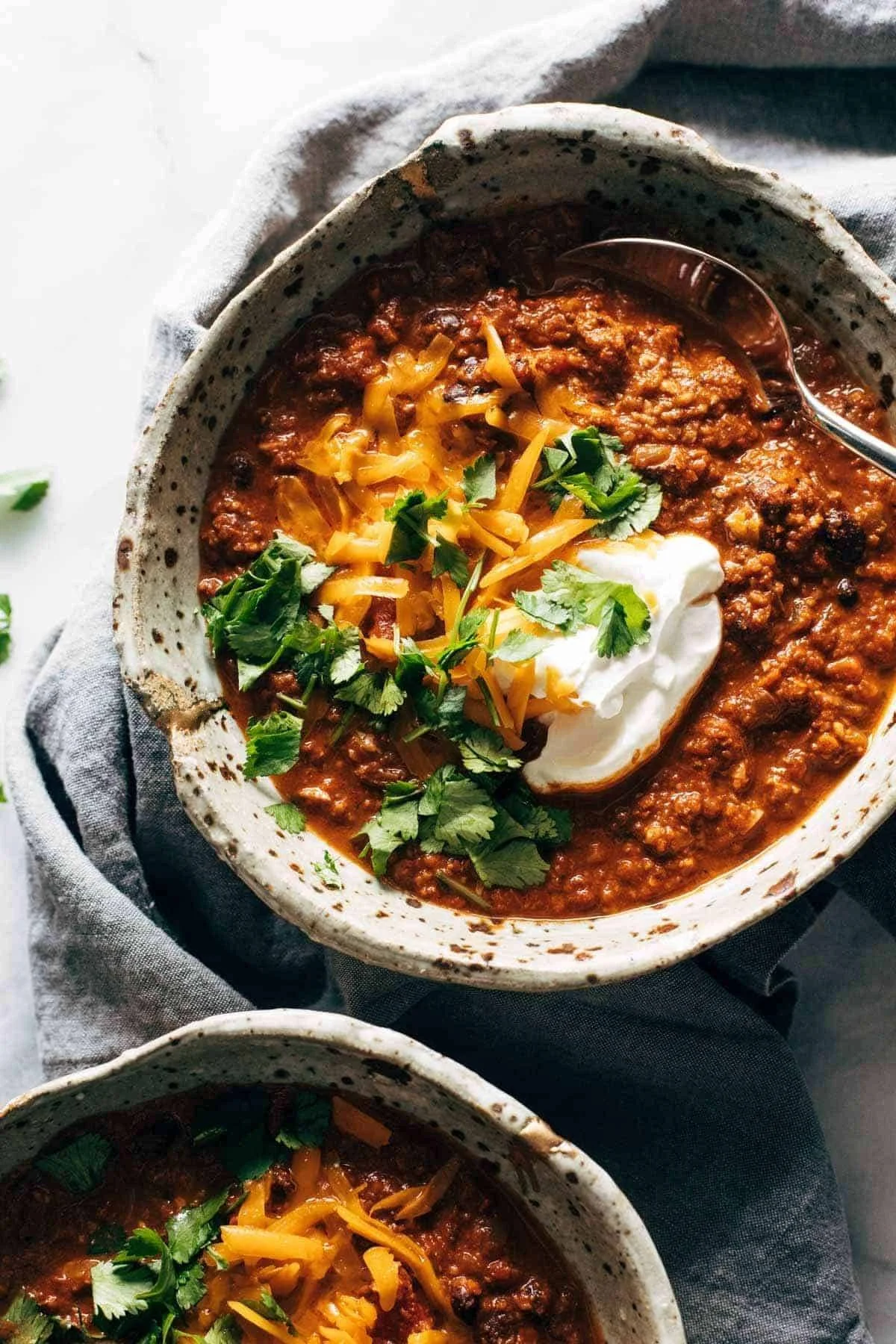 Bowl of hearty vegetarian chili topped with fresh herbs and served with bread