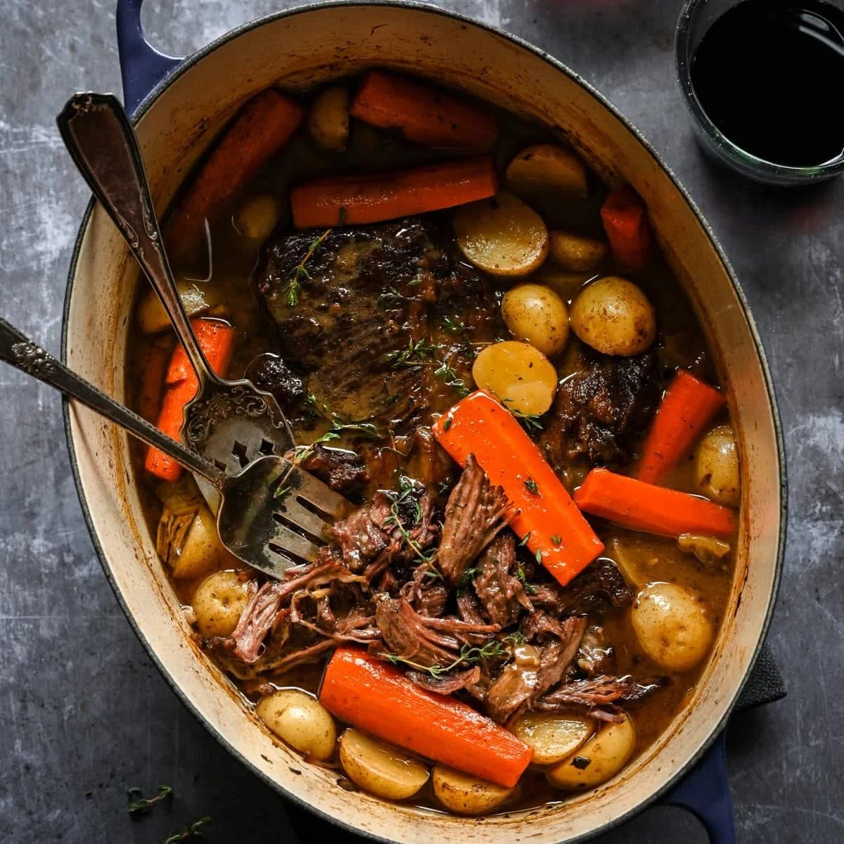 Delicious winter pot roast served with vegetables and herbs.