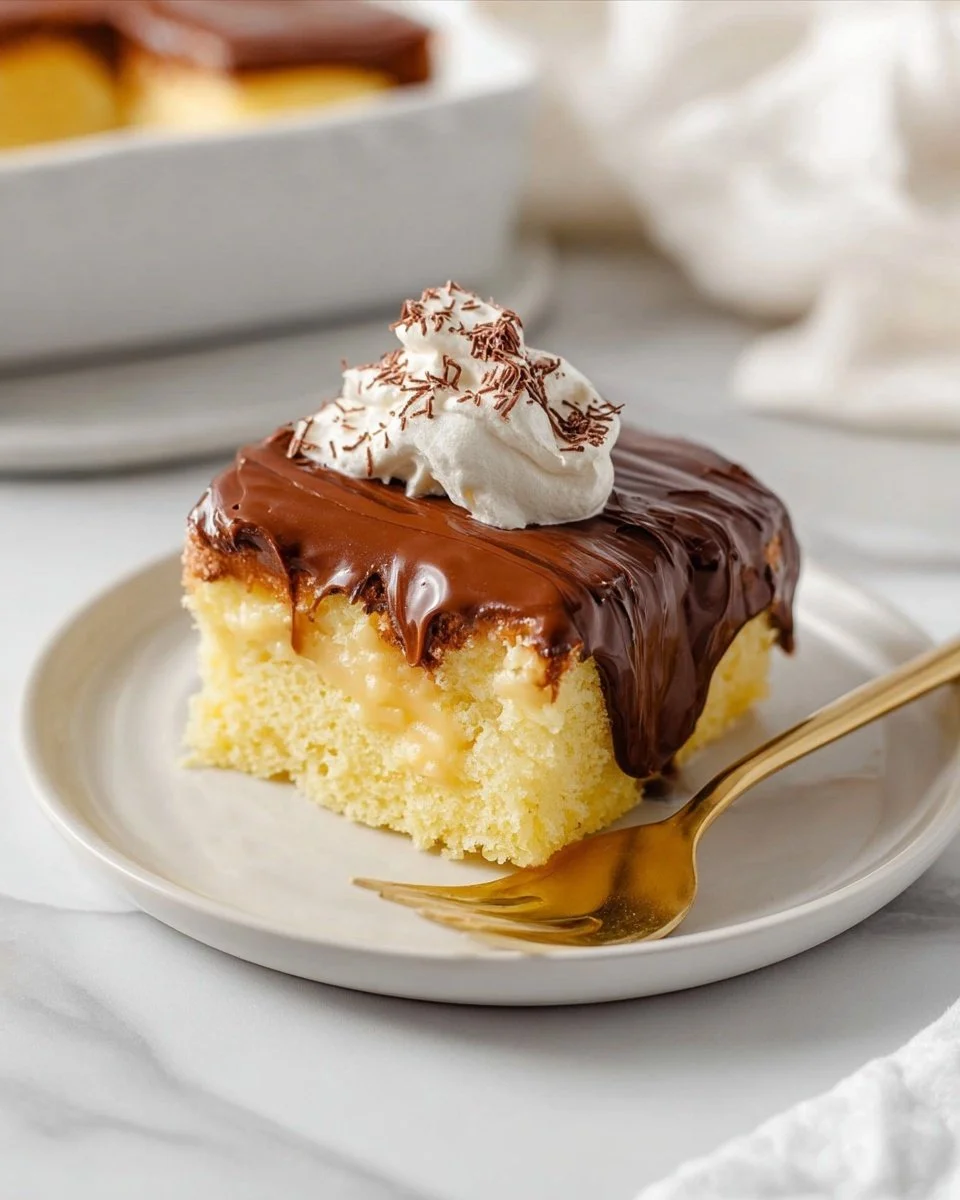 Delicious Boston Cream Poke Cake topped with chocolate and whipped cream