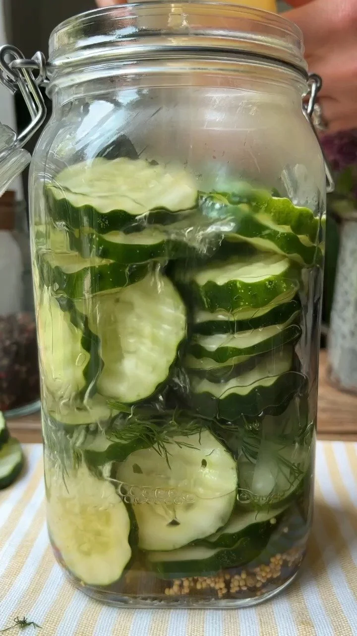Jar of homemade hot honey pickles with peppers and spices