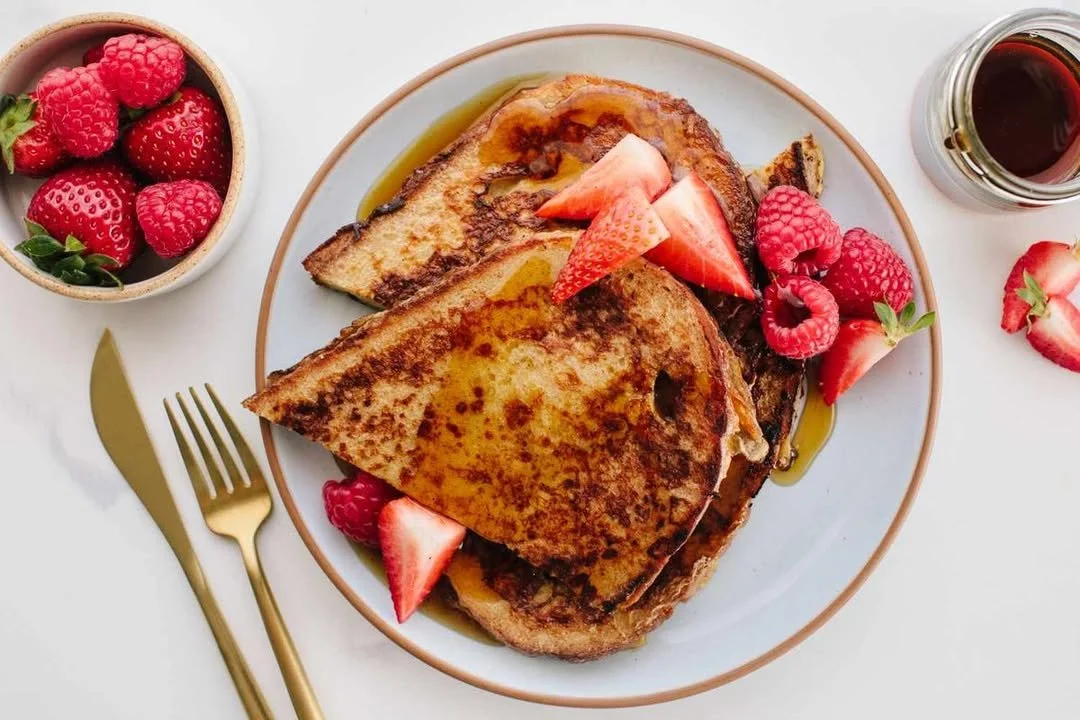 Deliciously golden sourdough French toast topped with fresh berries and syrup.